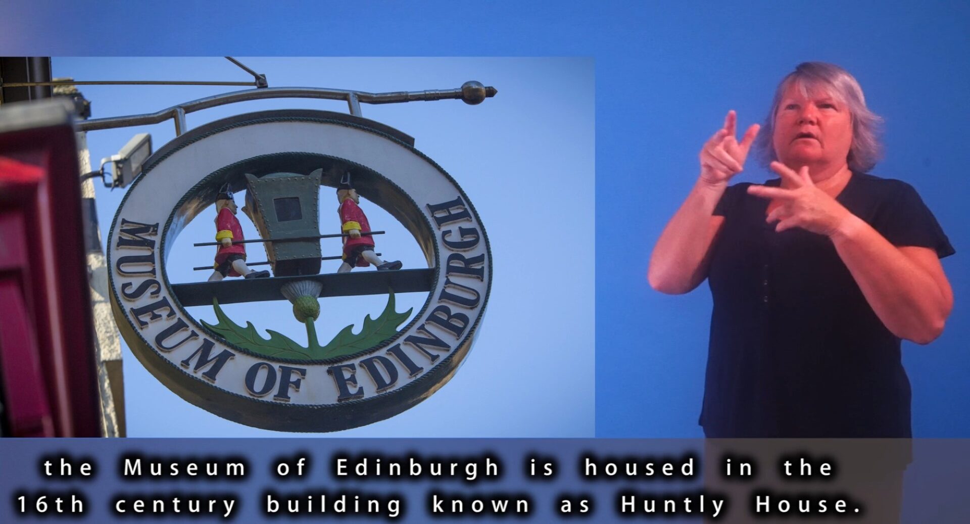 A BSL interpreter beside a photograph of the Museum of Edinburgh sign. Subtitles run along the bottom of the image, mentioning that the Museum is housed in the 16th century building Huntly House