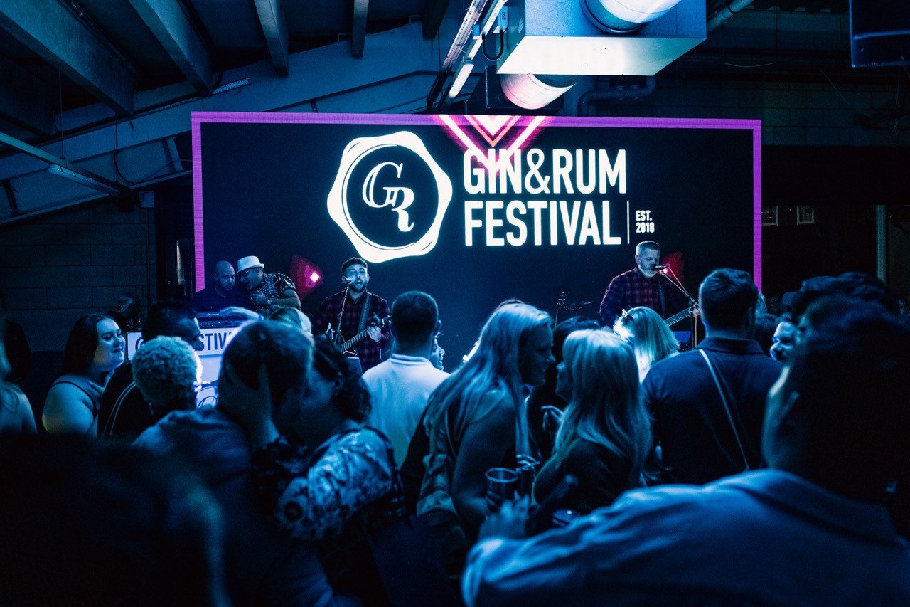 Band playing with crowd looking on at the Gin and Rum Festival