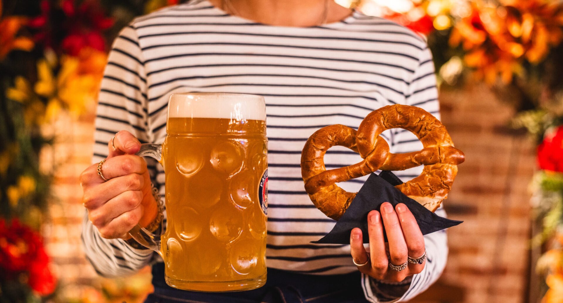 Lady holding beer and pretzel at Oktoberfest at Brewhemia