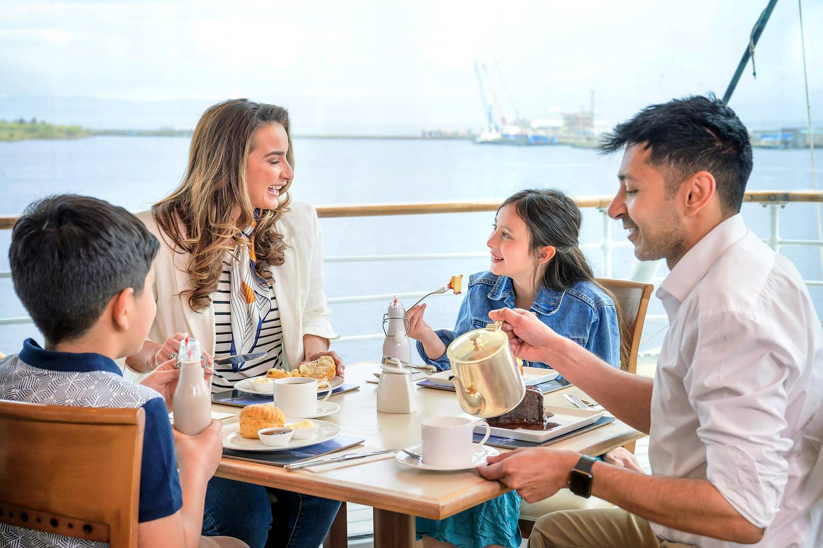 A family including a man, woman and little girl and boy are sitting in the Royal Deck Tearoom enjoying tea and scones. ,© Helen Pugh