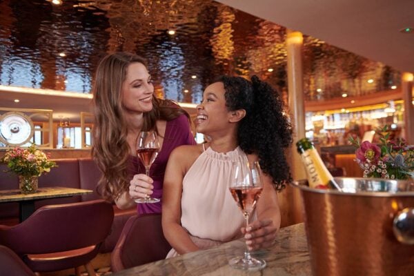 Two women smiling and enjoying drinks in The Lighthouse Restaurant & Bar.