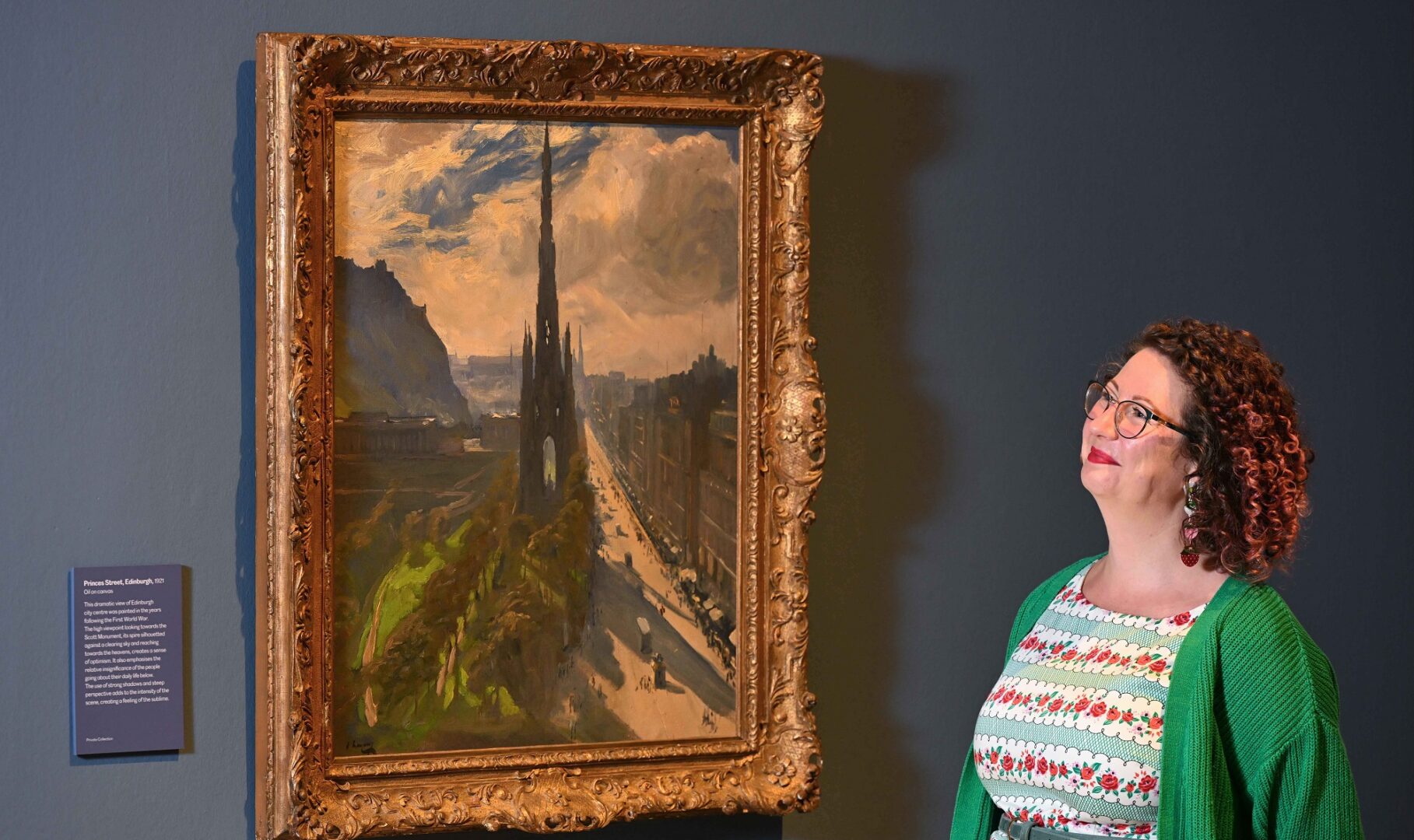 Lady stands next to a John Lavery picture of Scott Monument