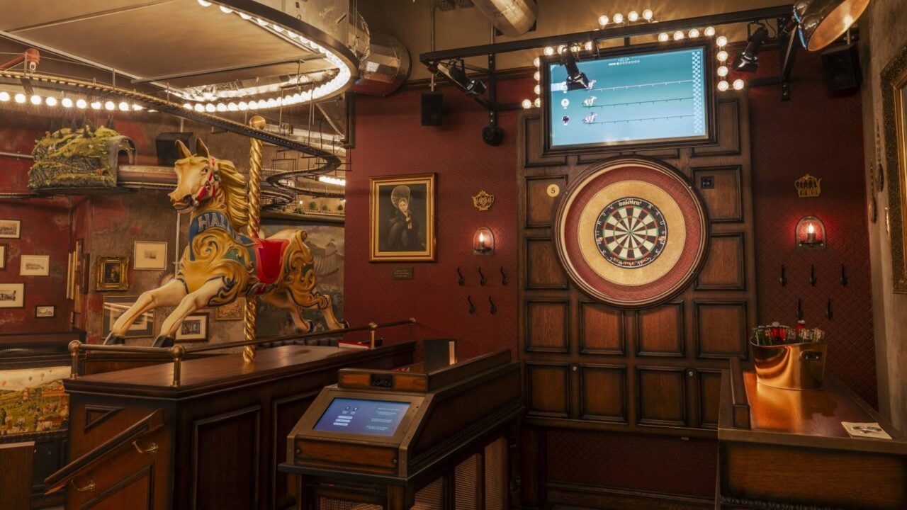 A photo of a Social Darts playing area, with a bucket of beers to the right on a table, and a carousel horse named Hallie.,© Flight Club Darts 2024