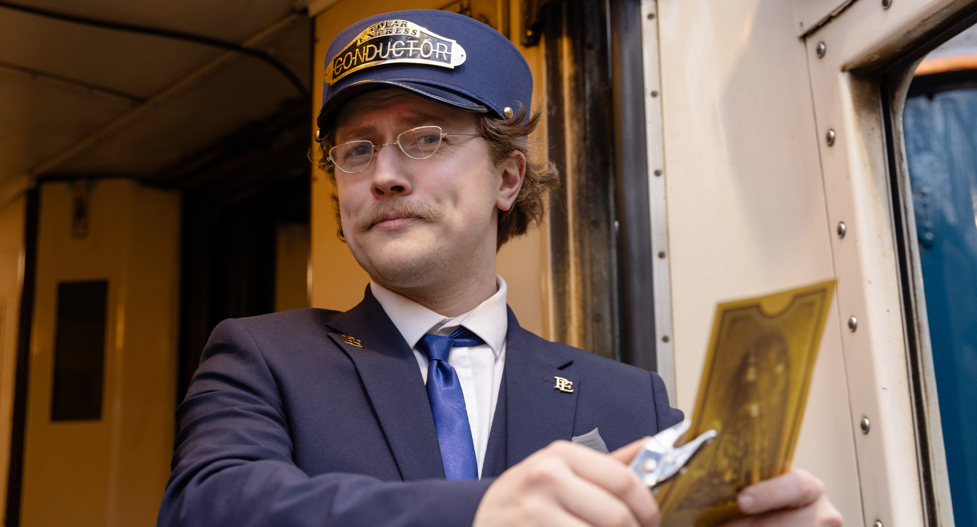 Train conductor clipping a golden train ticket