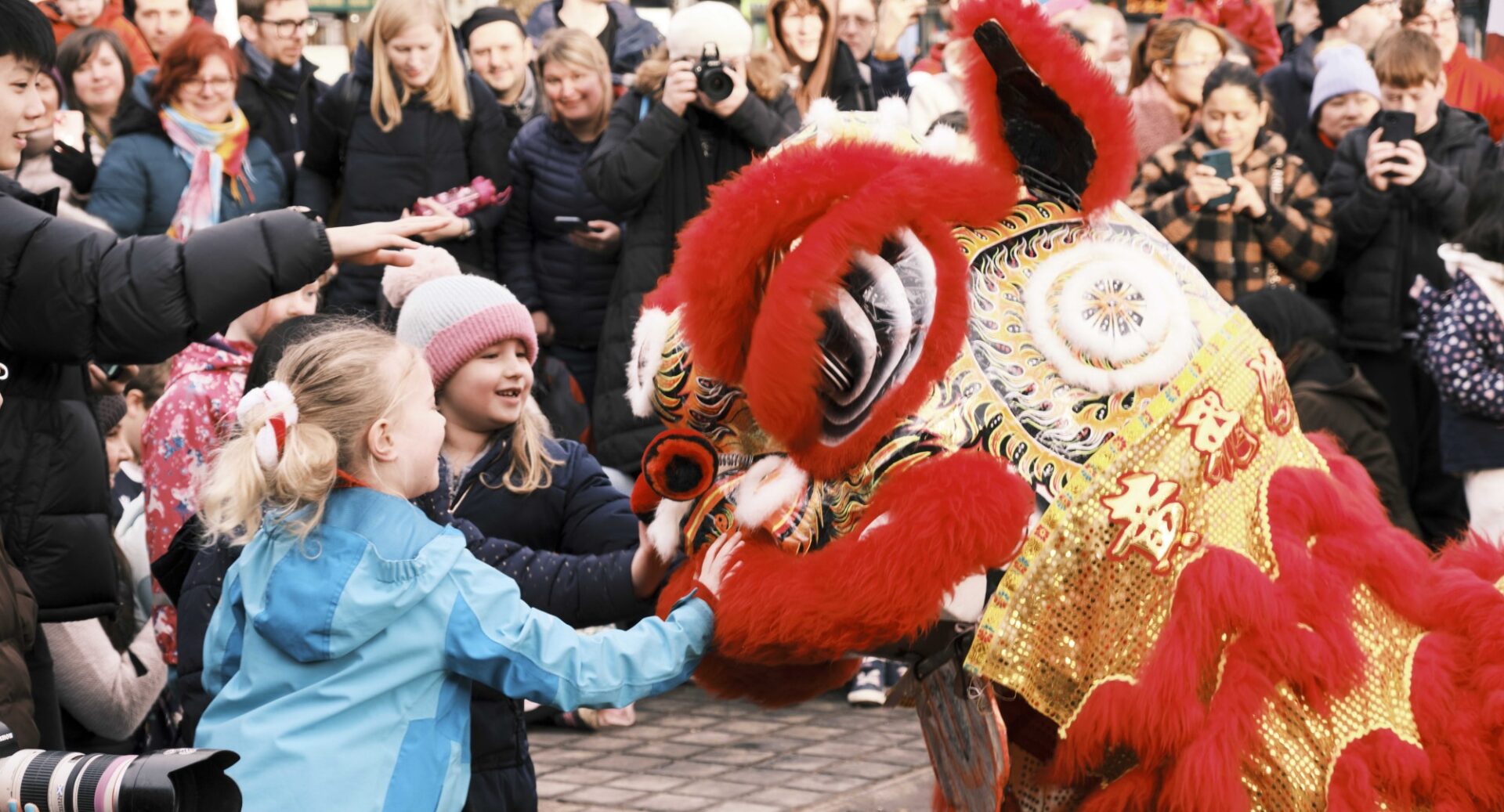 Children in the crowd lean forward to pat the nose of one of the Chinese dogs performing at the Mound