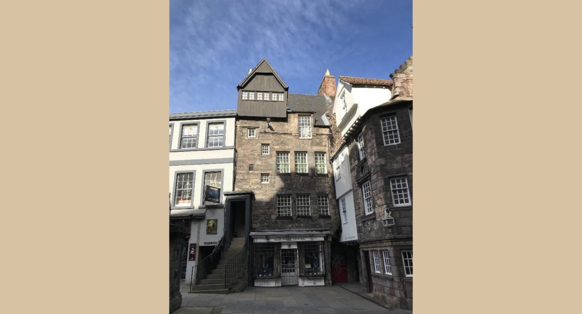 An exterior shot of Moubray House, where the Cockburn Association is based. It is a tall, narrow 5 storey building with muntin windows and steps leading up to the first floor. A shop is on the ground floor.
