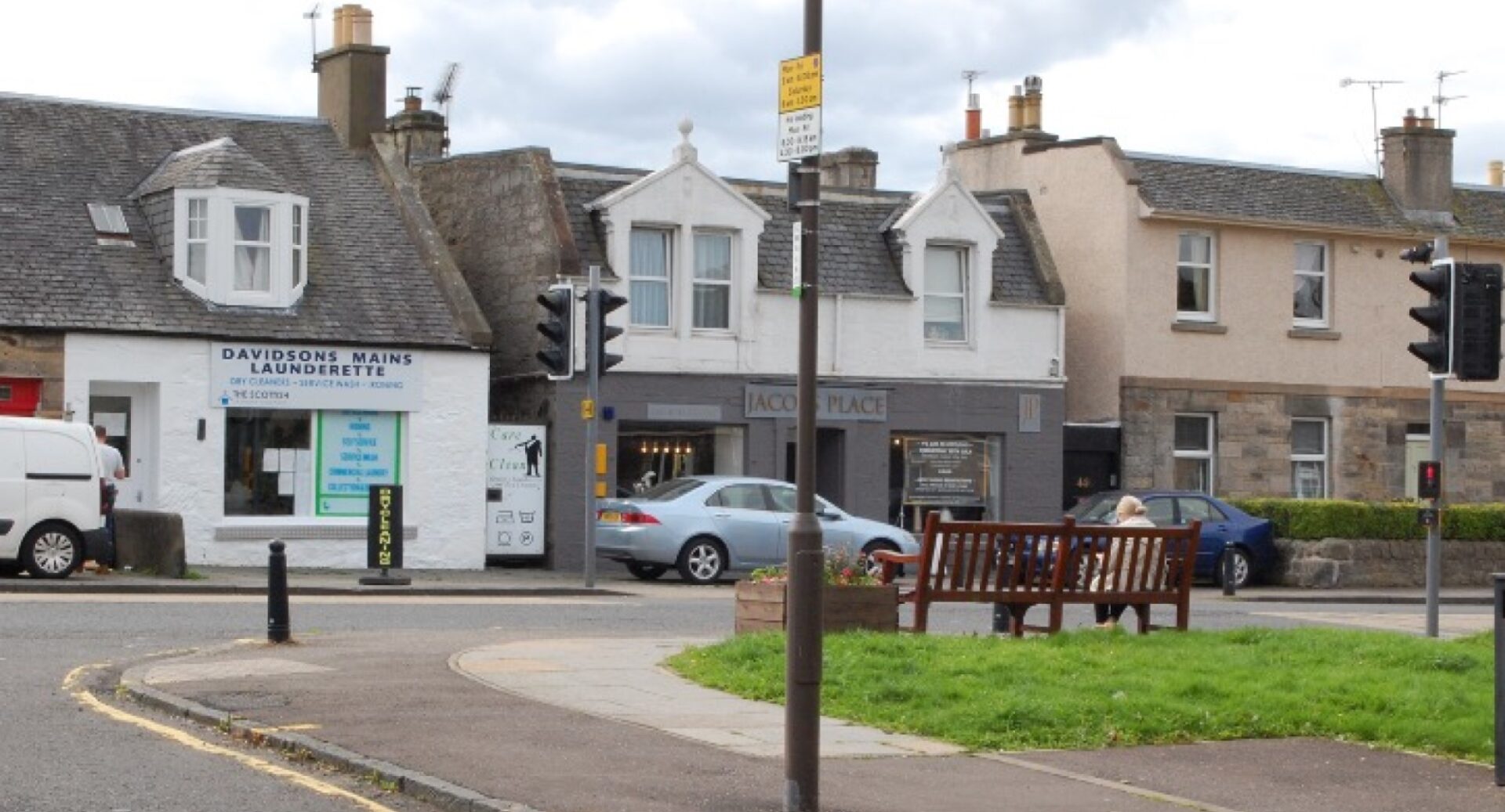 A modern day shot of Davidson's Mains showing the same row of buildings and a car in the background and an empty road leading out of the picture