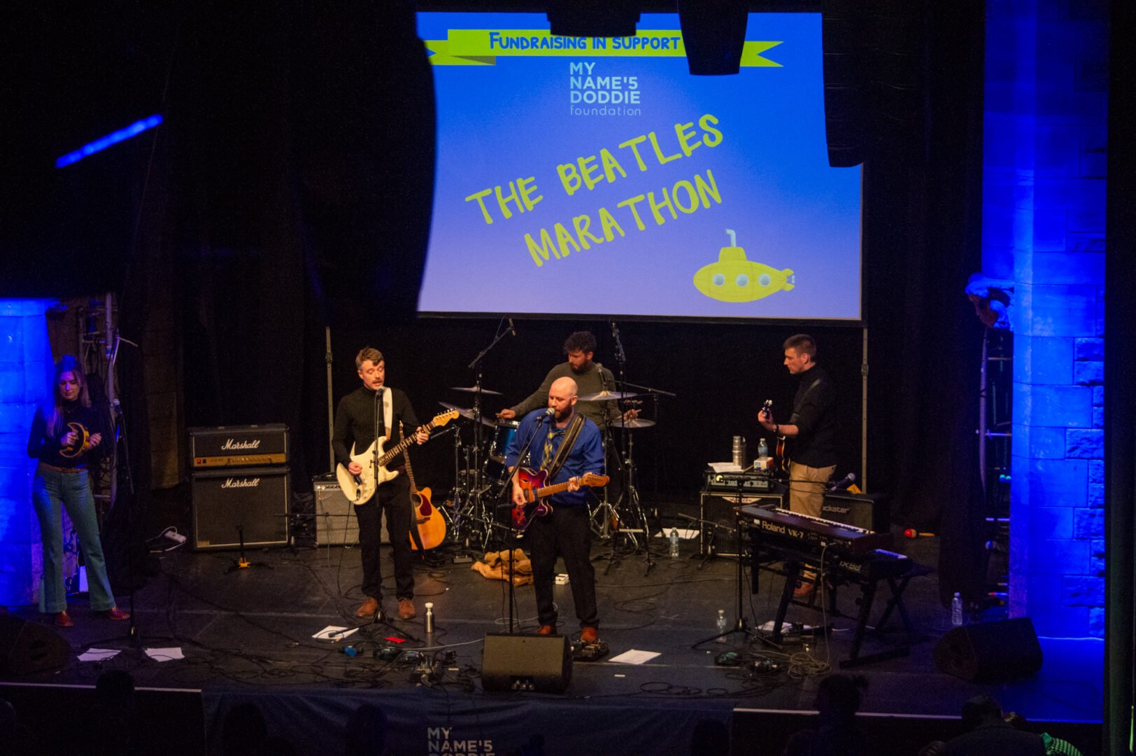 A band performing on a stage at the Beatles Marathon UK