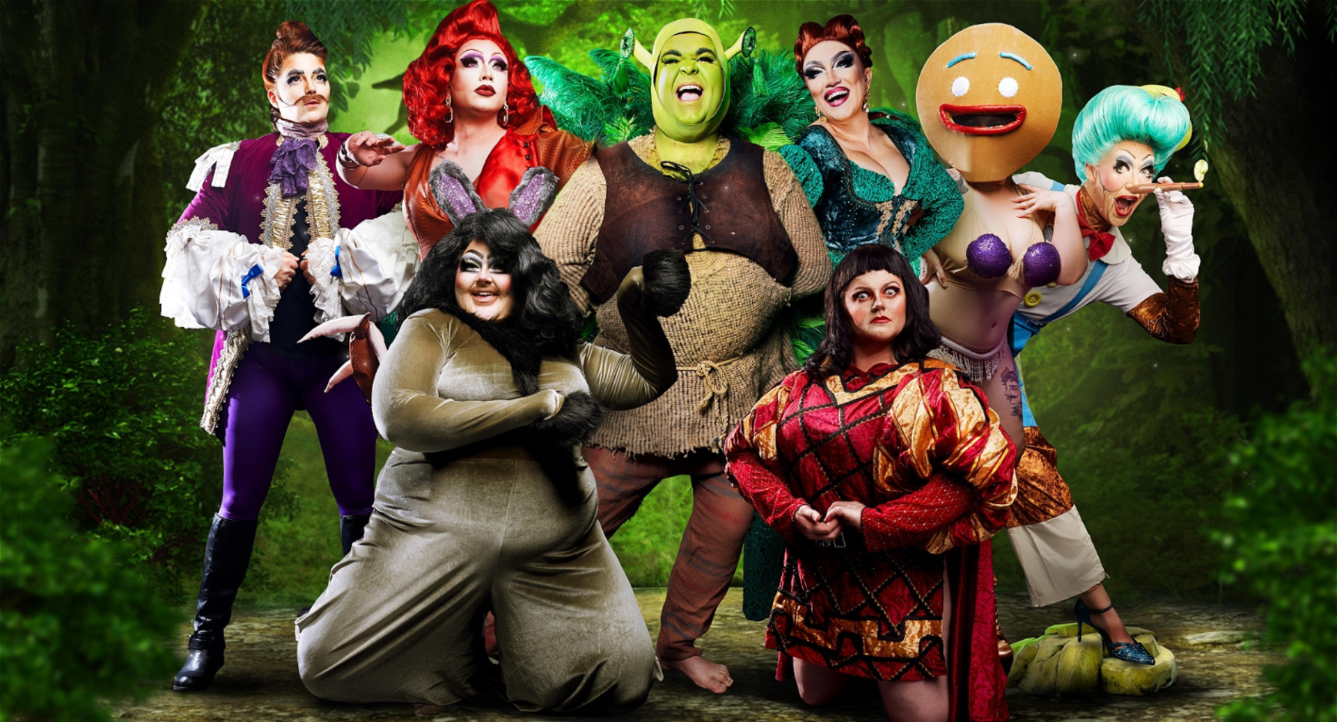 Group of 7 people dressed in burlesque and drag costumes. In the centre is an Ogre character.