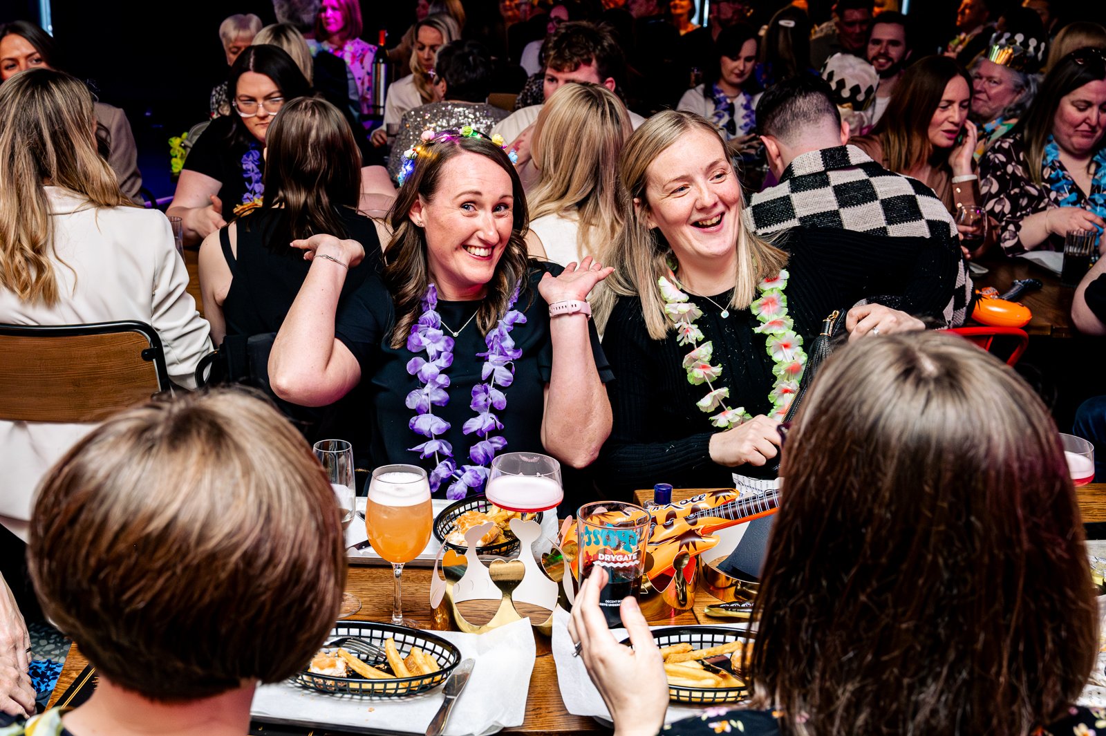 Two women posing happily for a picture at a celebration meal