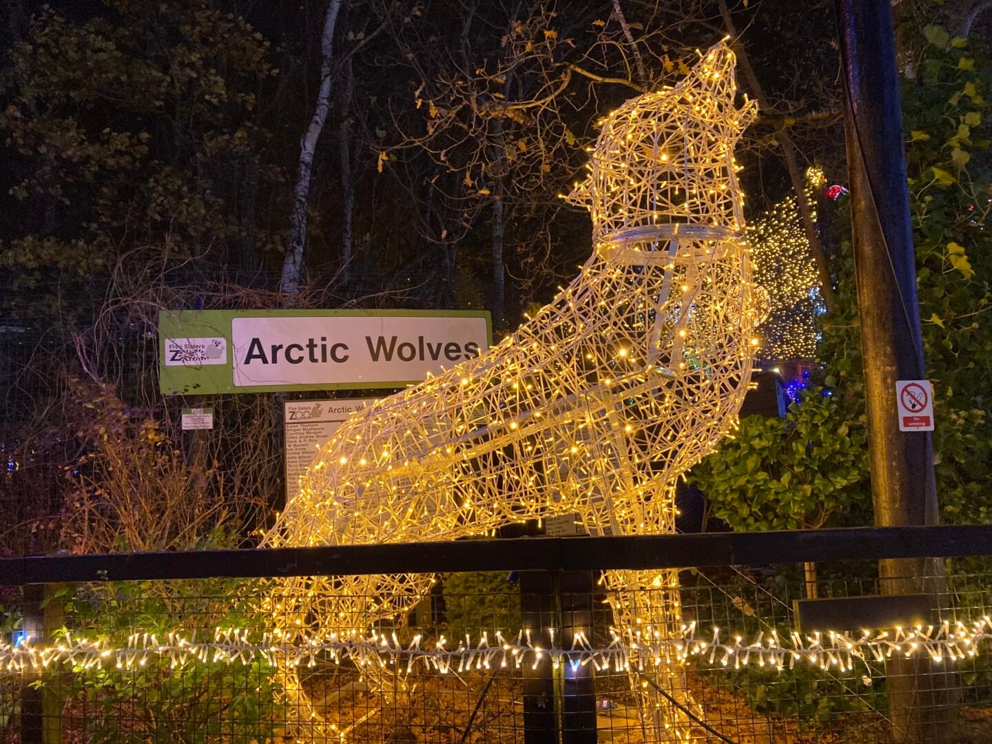 Display of a wolf, head raised howling, covered in lights,