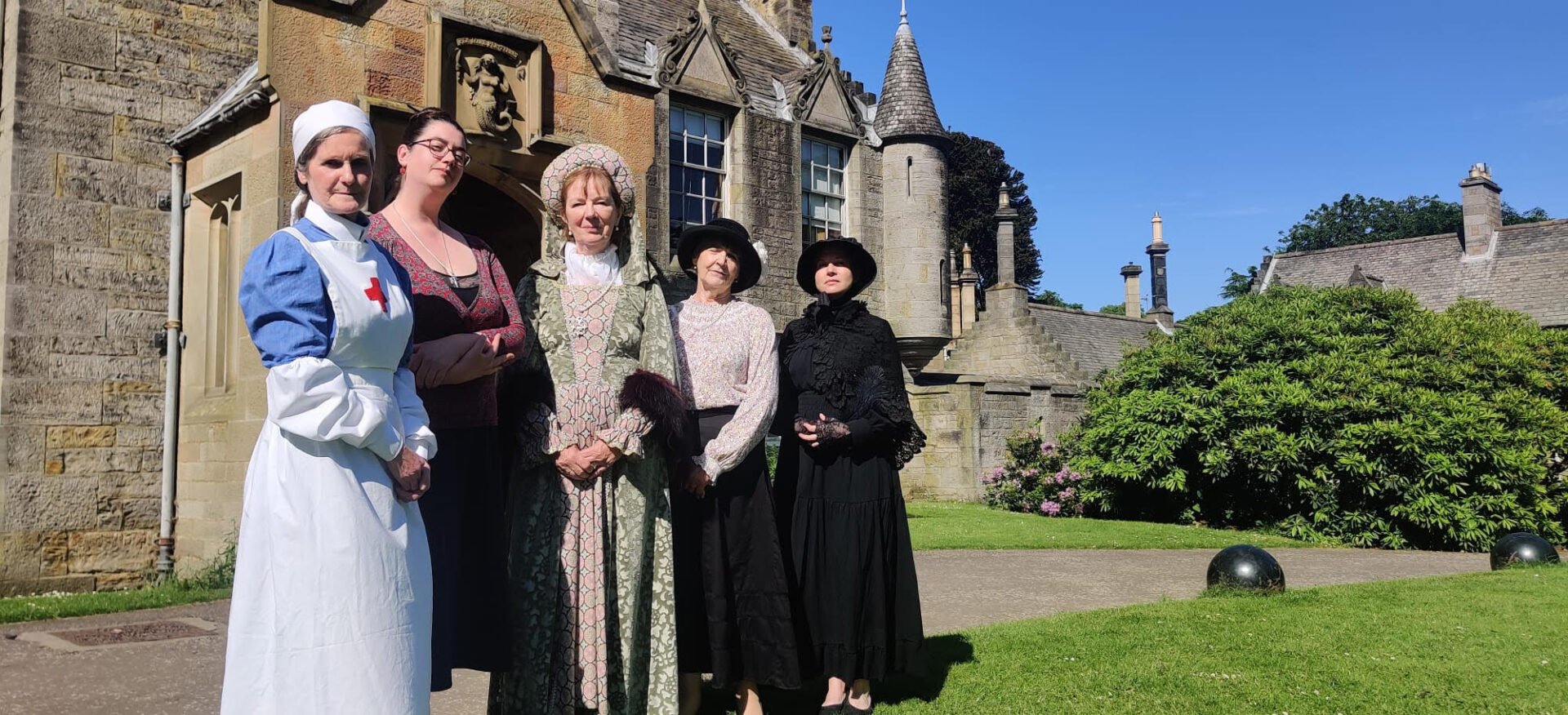 Edinburgh Living History actors dressed up in Edwardian garb to represent female staff and residents at Lauriston Castle. The entrance to the Castle is behind them.