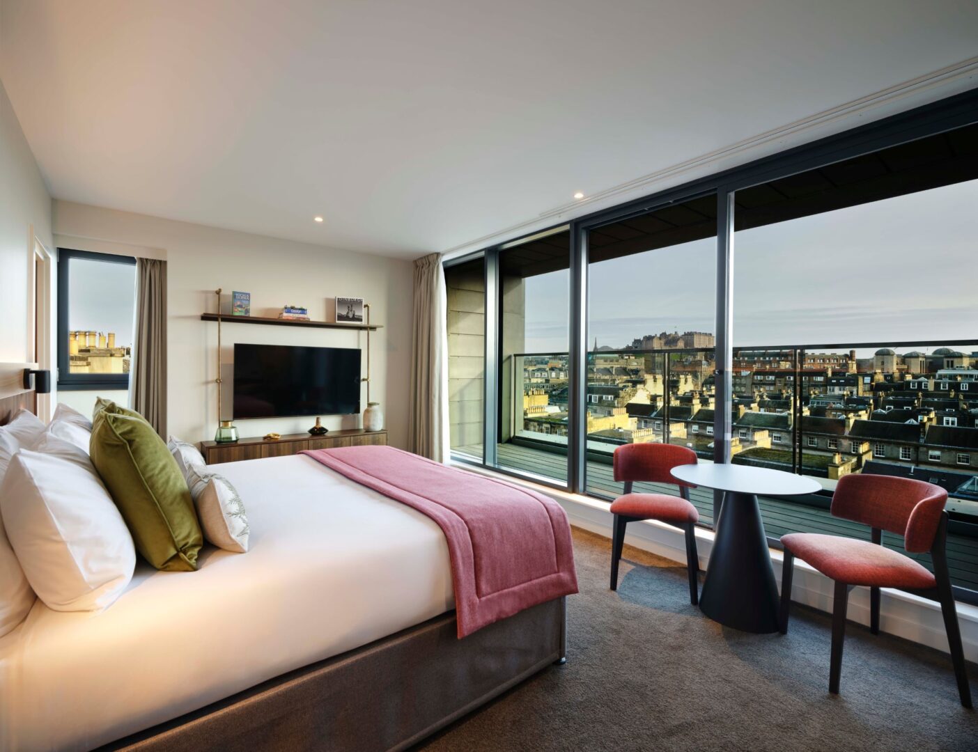 Double bedroom, with wide floor to ceiling window, with views of city skyline.