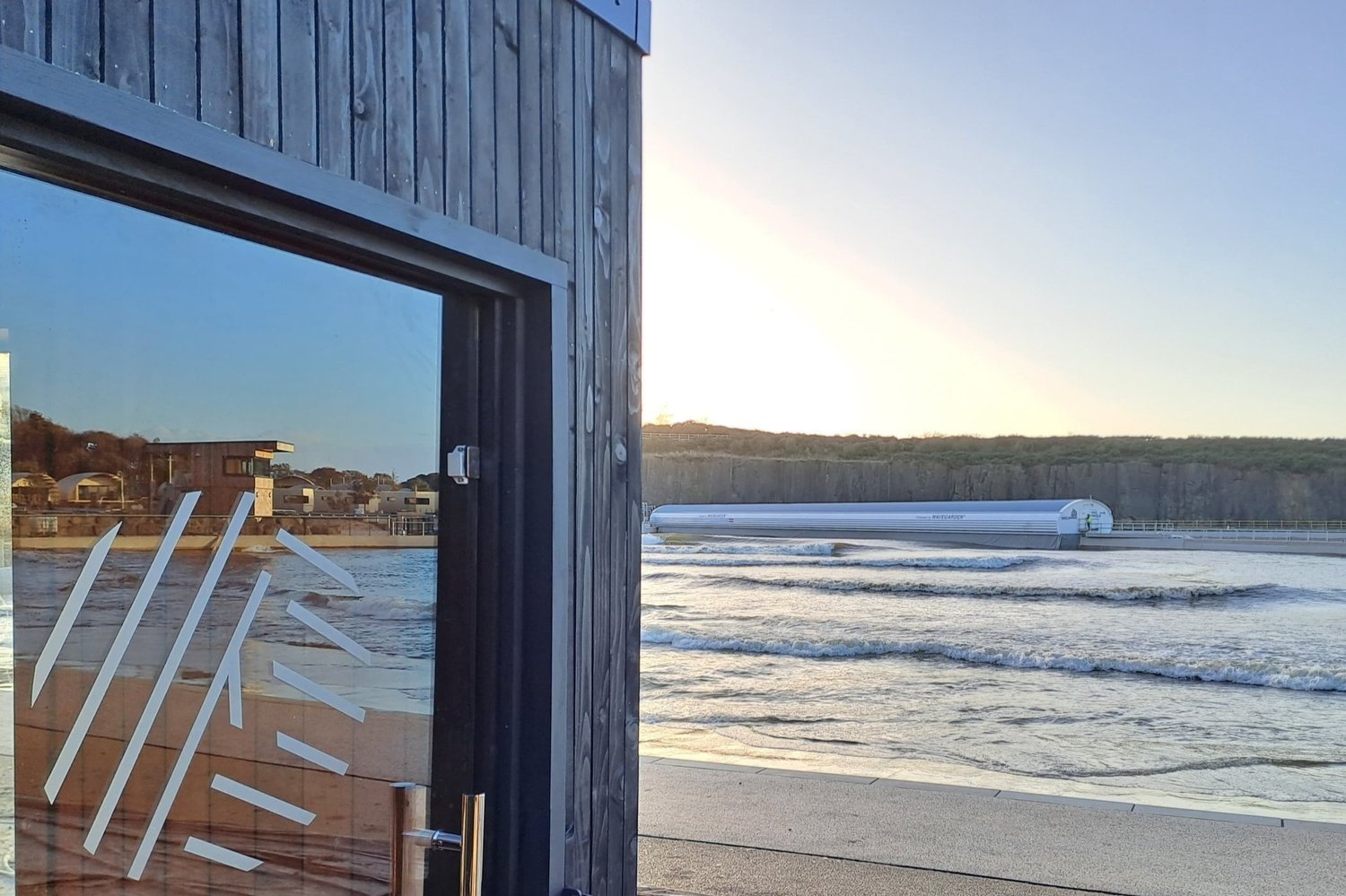 View from side of hut of a wave machine and waves.