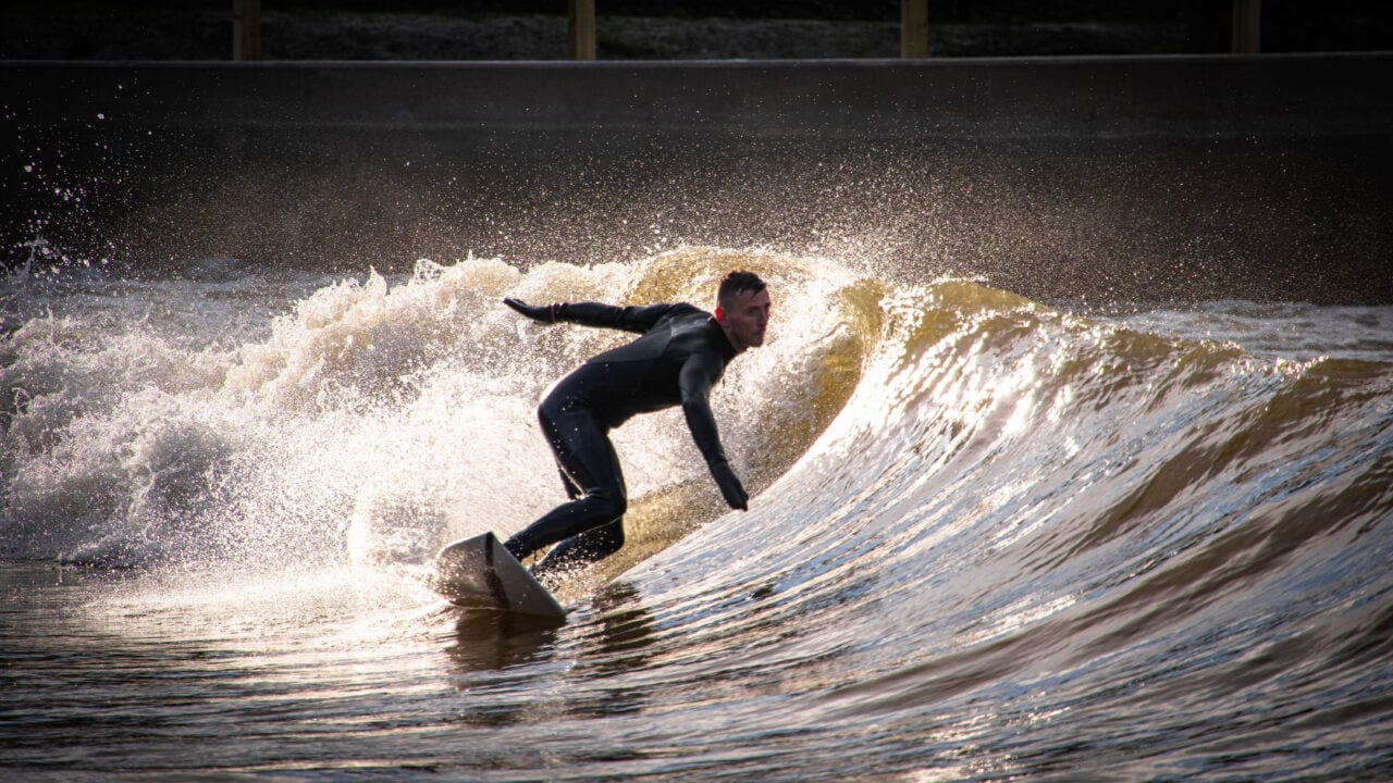 Person on surf board surfing over a tall wave.