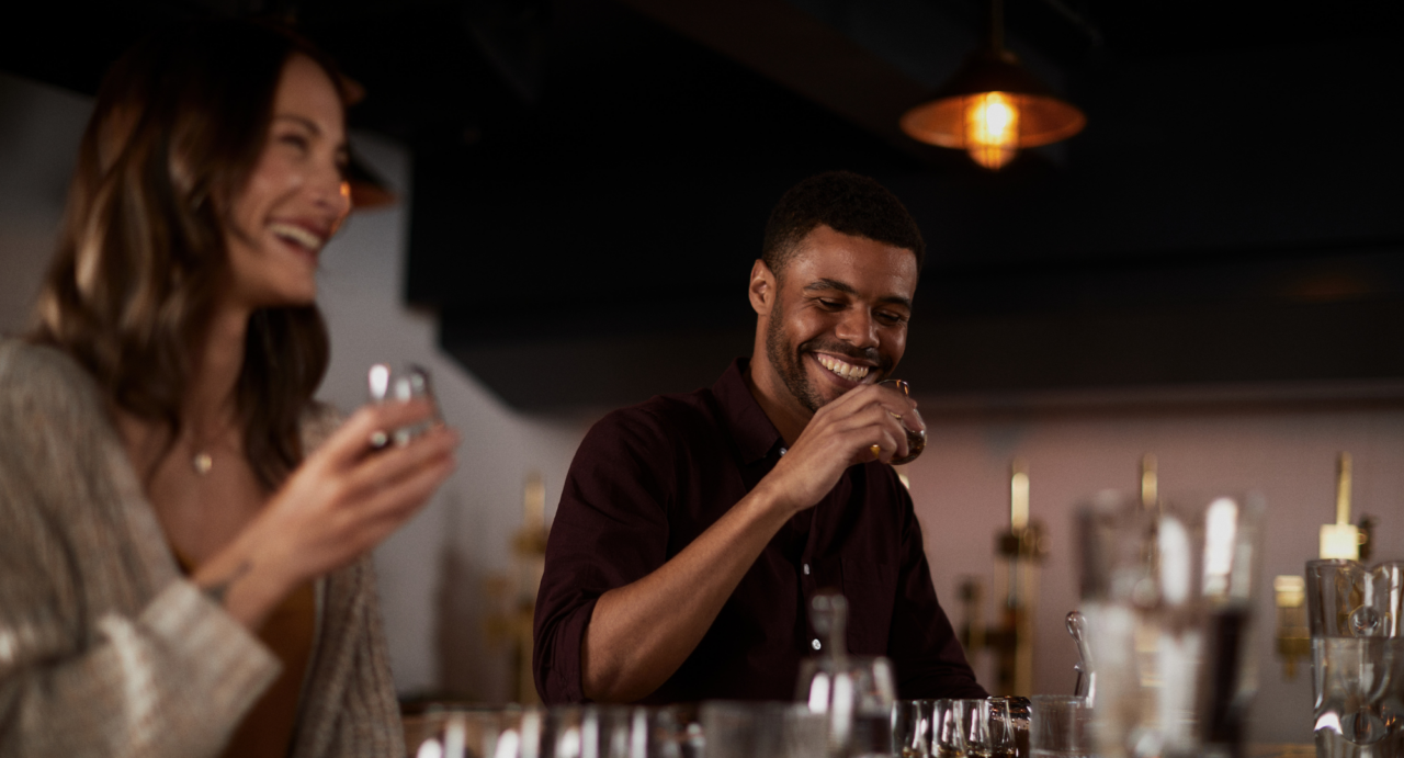 Man and woman enjoying a taste of Whisky at the Johnnie Walker Princes Street Journey of Flavour Tour.