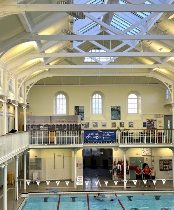 A shot of Glenogle pool, with bunting across, showing staff on the poolside and the mezzanine behind the balcony above