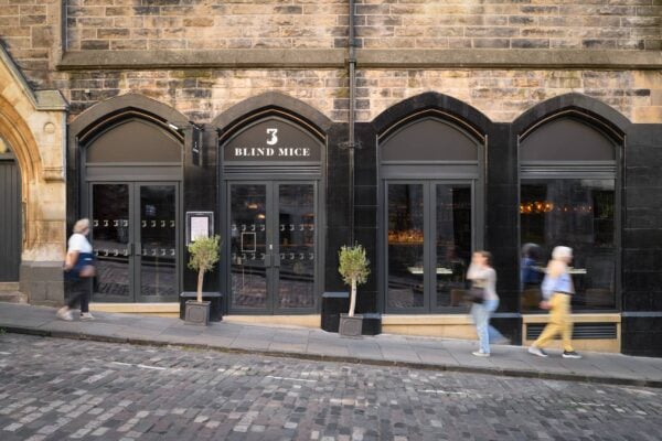 Exterior of the restaurant, set in old-town Edinburgh. The building features 2 arched doorways and 2 arched windows, painted black set into a traditional Edinburgh sandstone building.,© 3 Blind Mice - photography by ZAC and ZAC