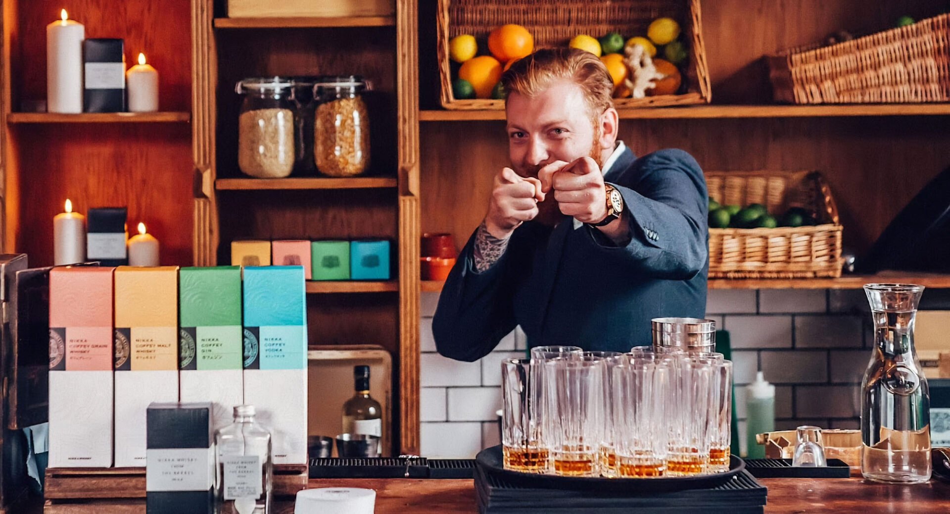 Bartender pointing at camera while serving whisky at the bar.