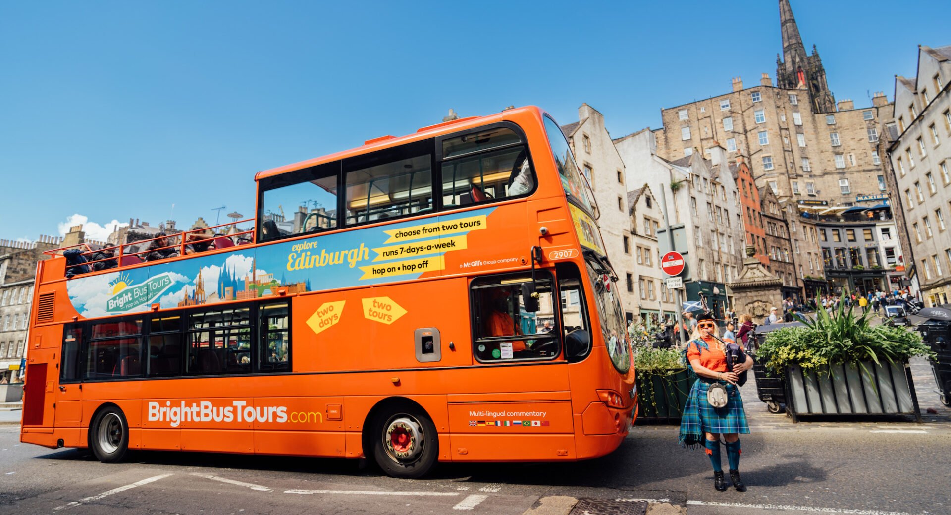 Bright Bus with piper in the Grassmarket