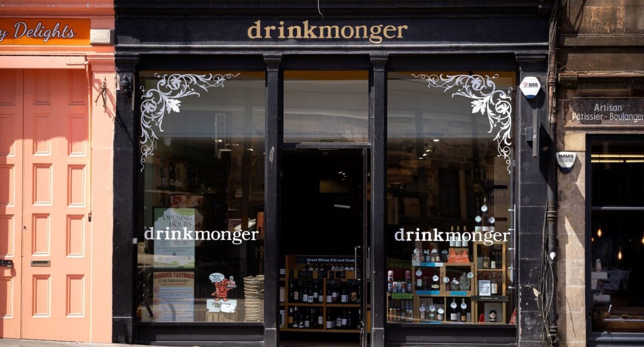 Exterior of shop window, with displays of drinks bottles visible.