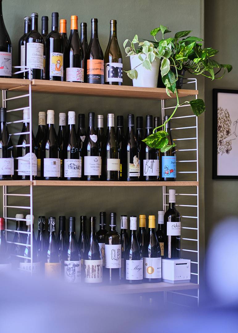 Shelf with wine bottles at WineKraft by Good Brothers