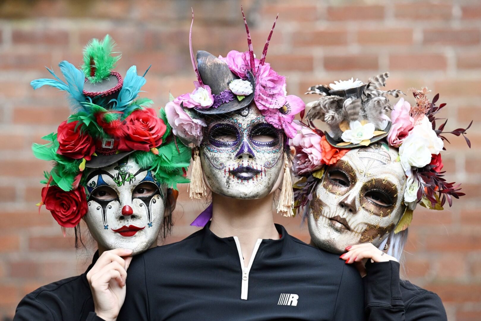 3 people wearing elaborate masks.