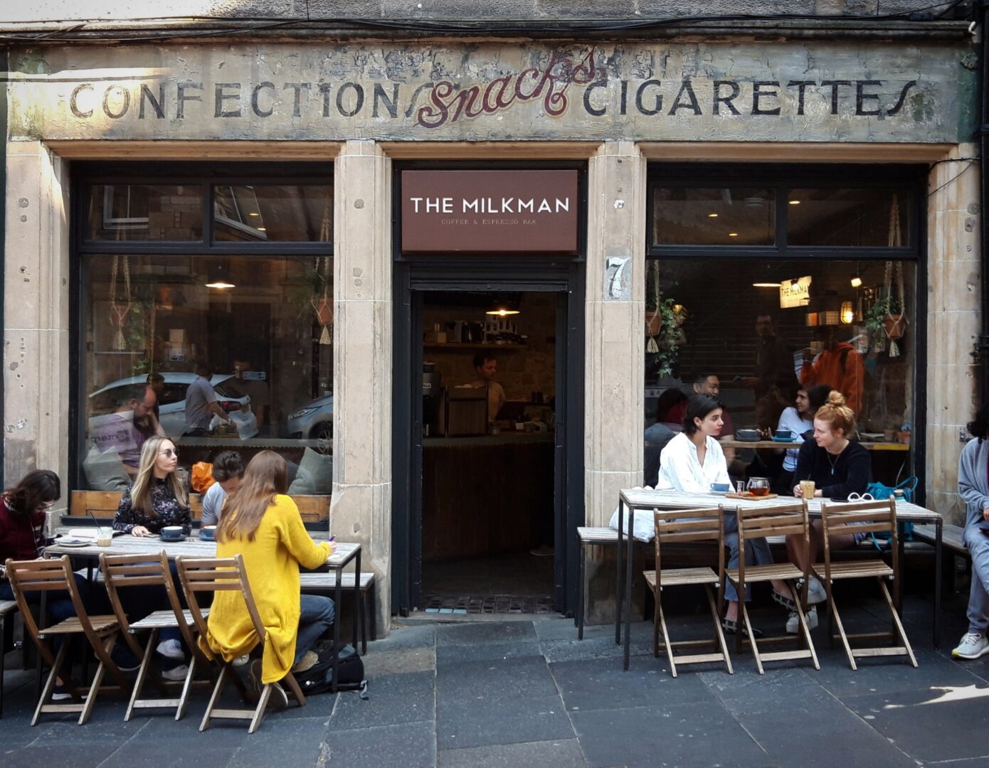 Exterior of The Milkman Coffee Shop with people sitting on seating outside enjoying coffee and tea.