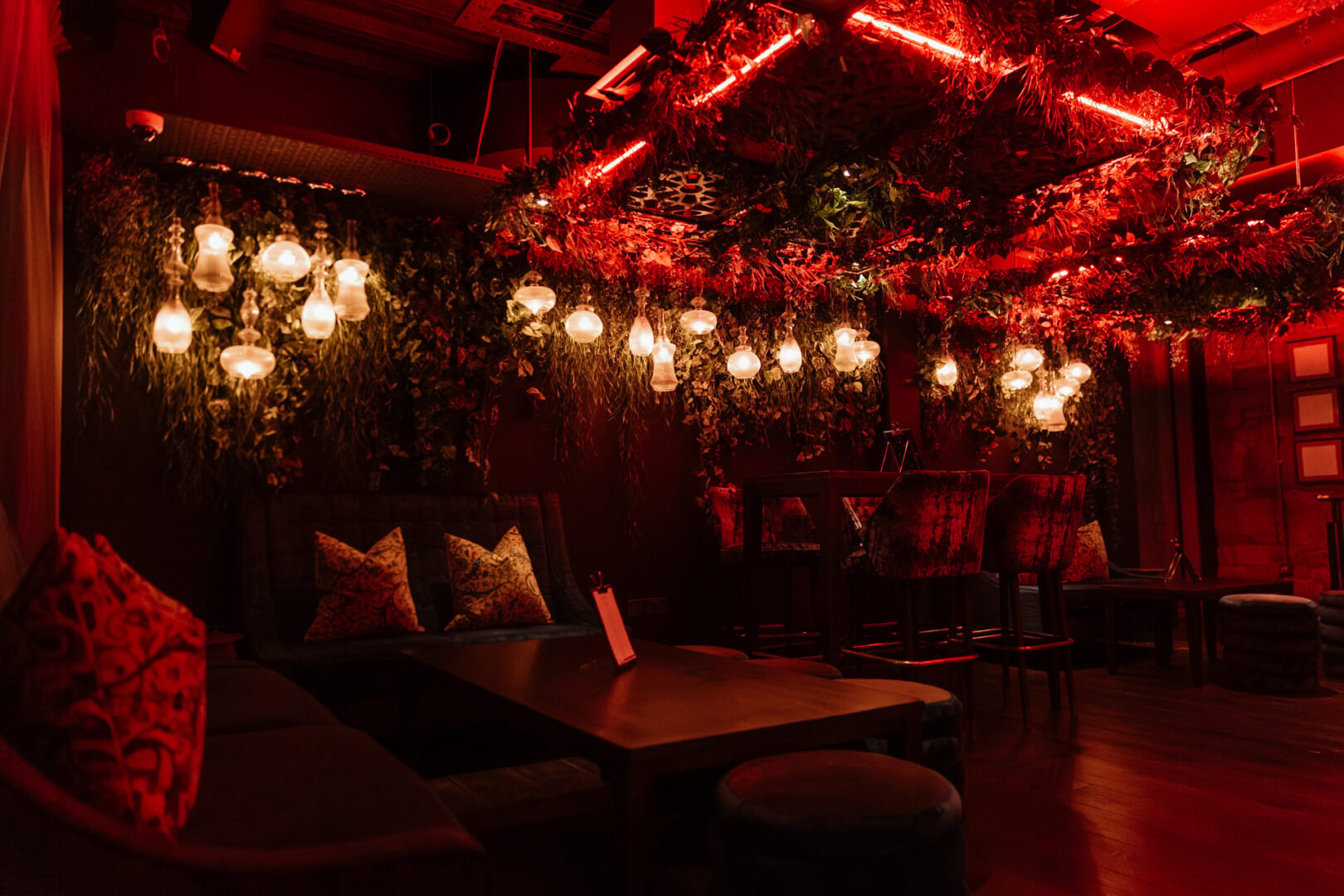 Bar area, with low-level lighting, tables and chairs.