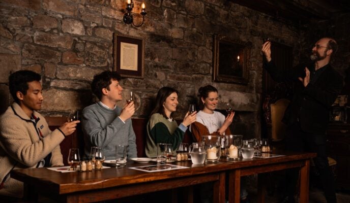 Group pf people taking part in a whisky tasting with a Mercat Tour guide