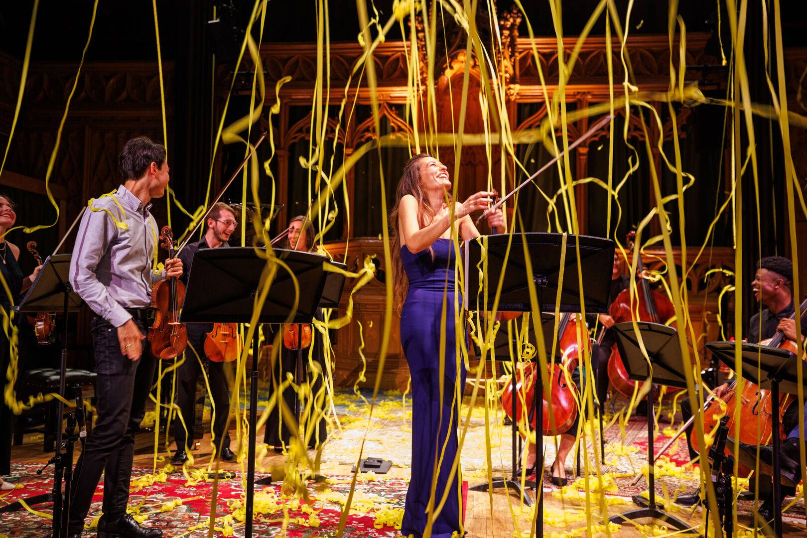 Nicola Benedetti stands in the middle of the stage smiling with streamers reigning down upon her.,© Andrew Perry
