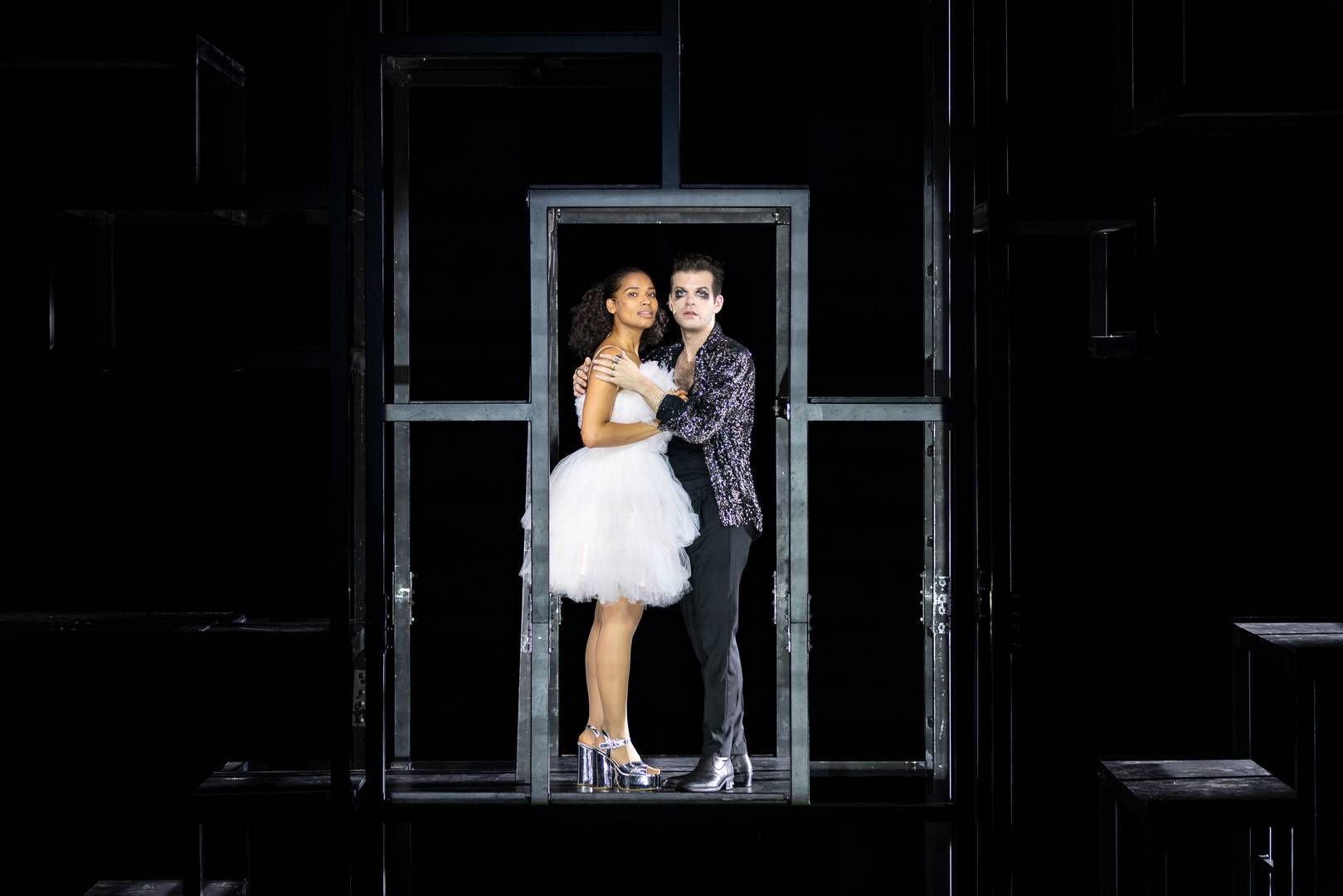 A man and a woman stand in the middle of a dark stage during a scene from the Three Penny Opera ,© Jess Shurte