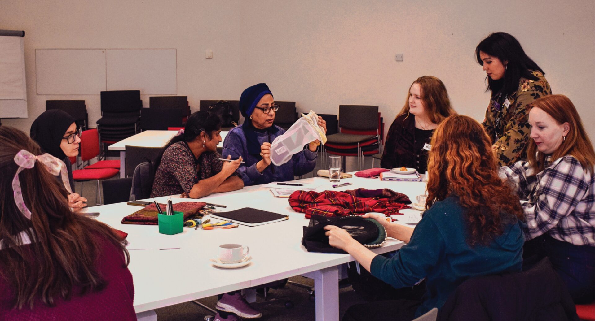 A group of women sitting around a table working on their fashion creations