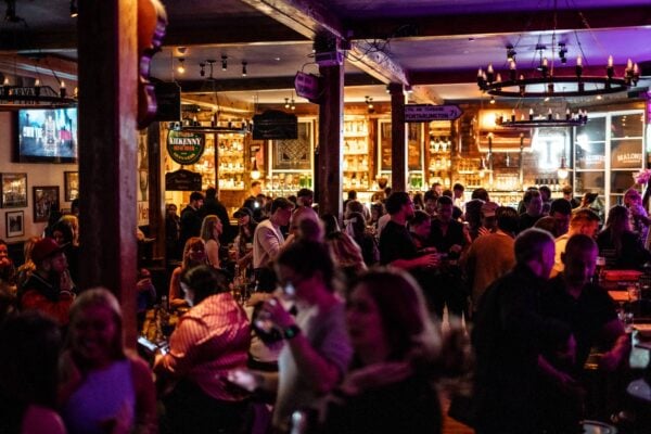 Large crowd inside a pub with exposed wooden beams and chandeliers ,© Malones Edinburgh