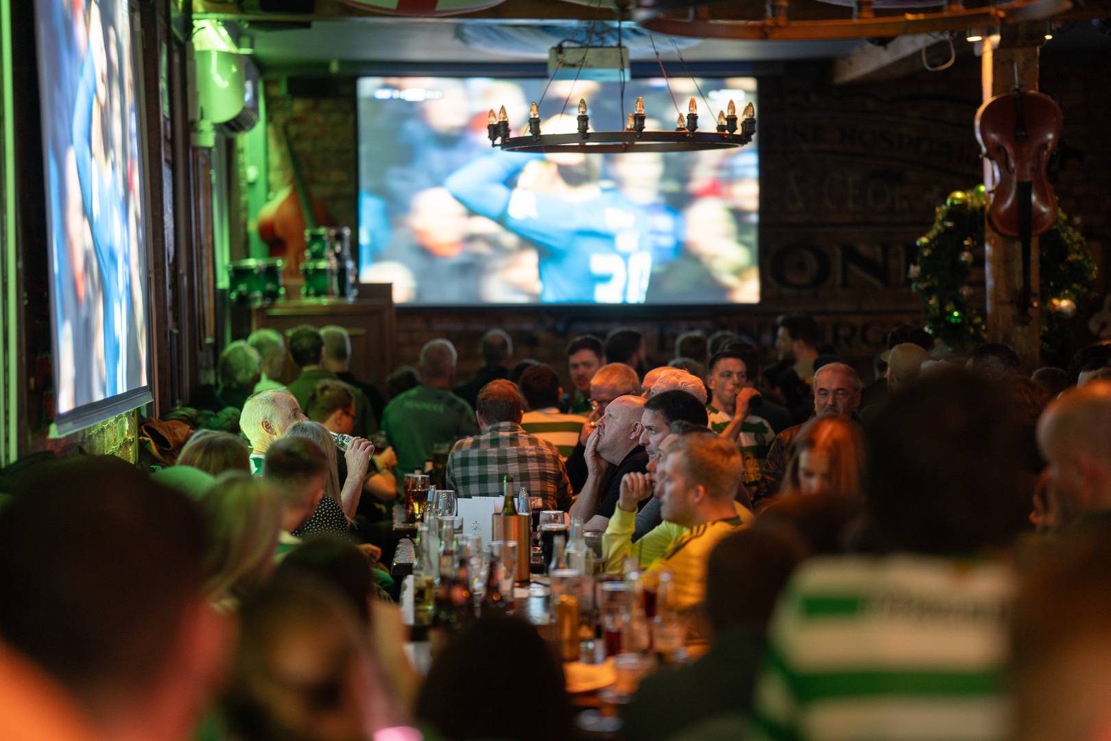 2 screens on the walls of a pub showing a football match,© Malones Edinburgh