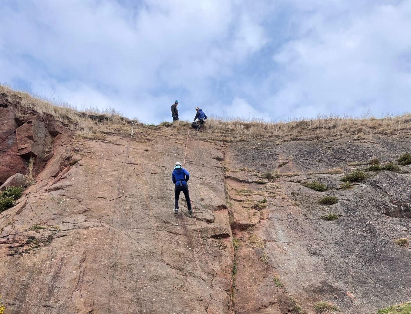 a climber abseiling down a rock face
