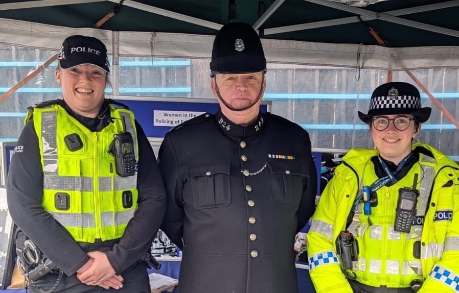Three police officers in uniform, one historical.