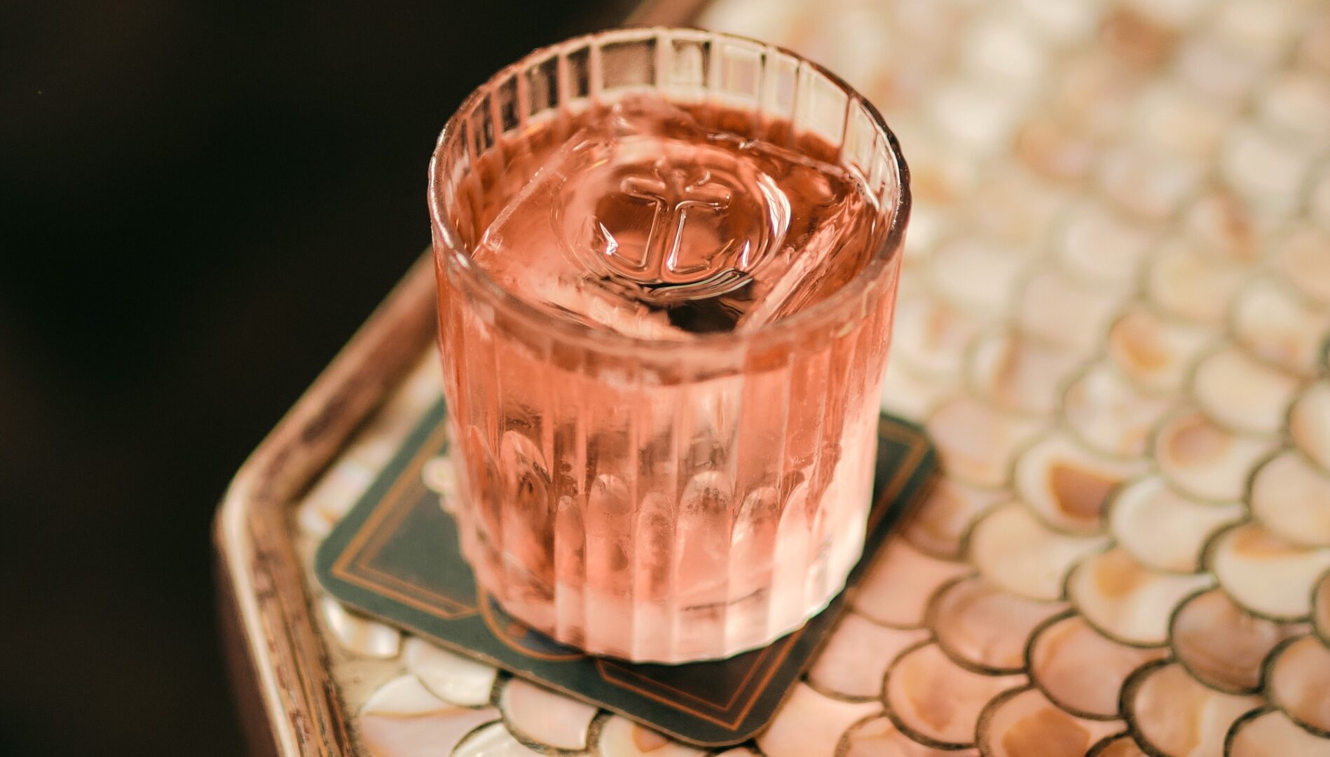 A pink cocktail sat on a table edge in Nauticus