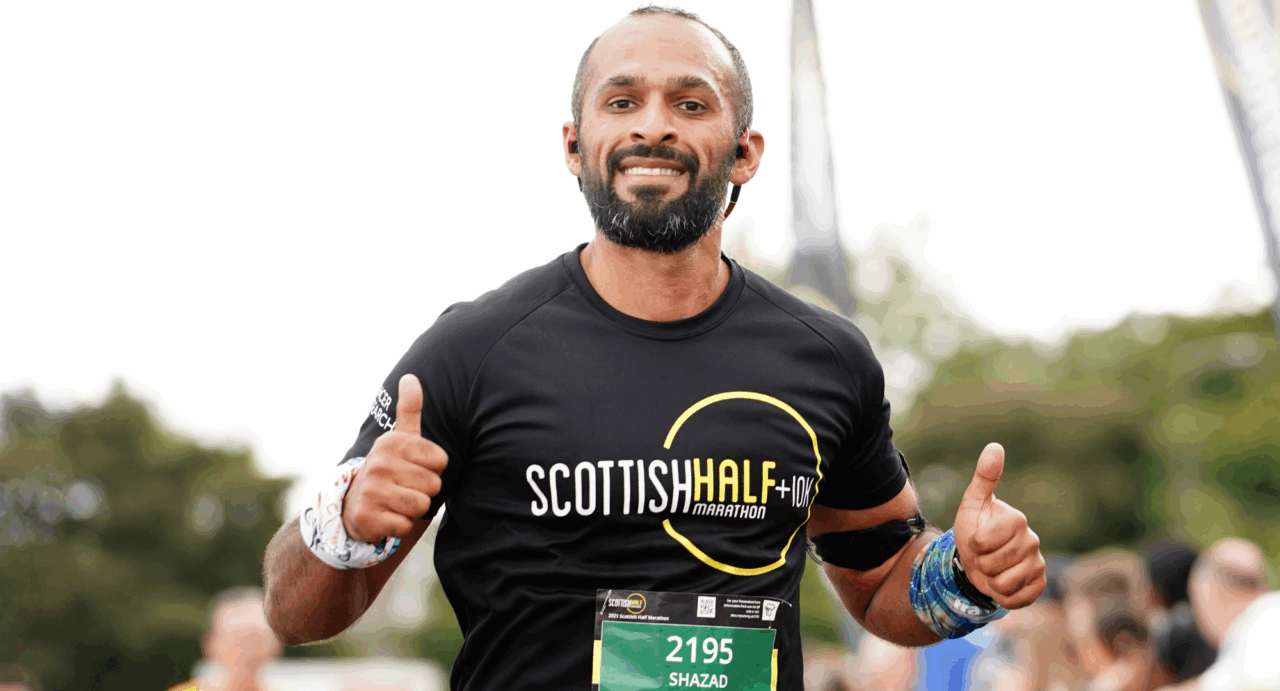 Man running, giving a thumbs up signal.