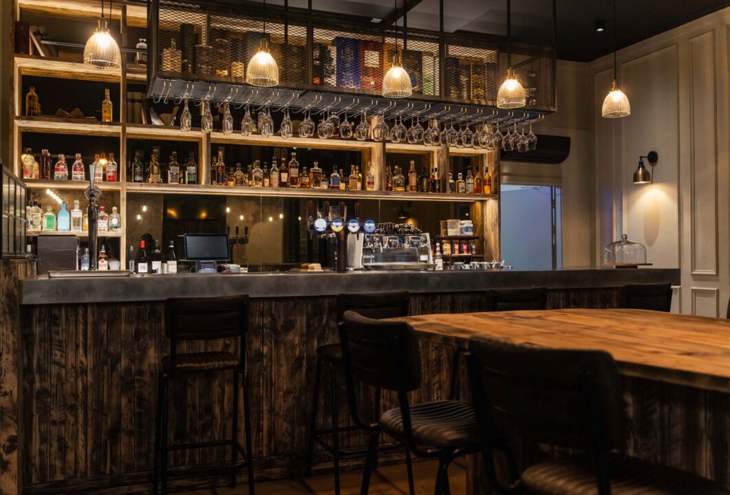 Bar, with rows of bottles and a large table.