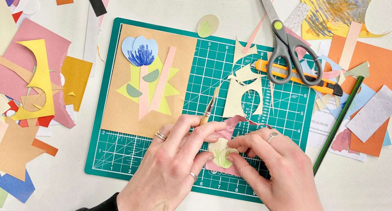 A pair of hands making a paper flow. On the table are a mix of different paper shapes and sizes