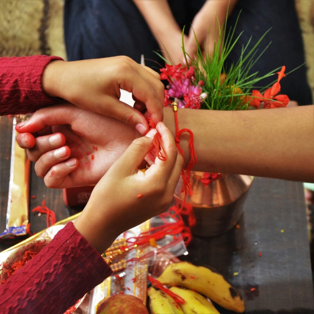 A Rakhi bracelet being tied onto a woman's wrist