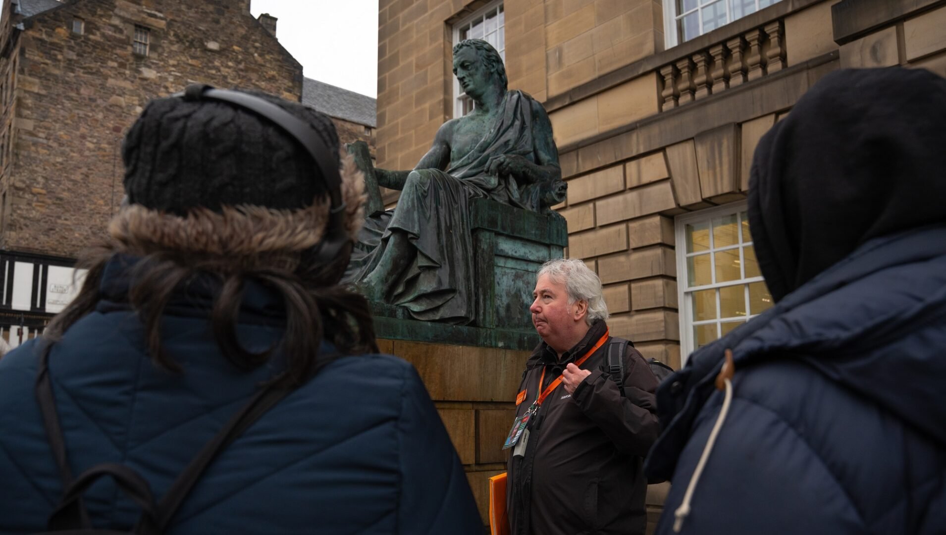 Group of people with a Mercat Tour Guide next to the David-Hume Statue on the Enlightenment-Edinburgh-tour-