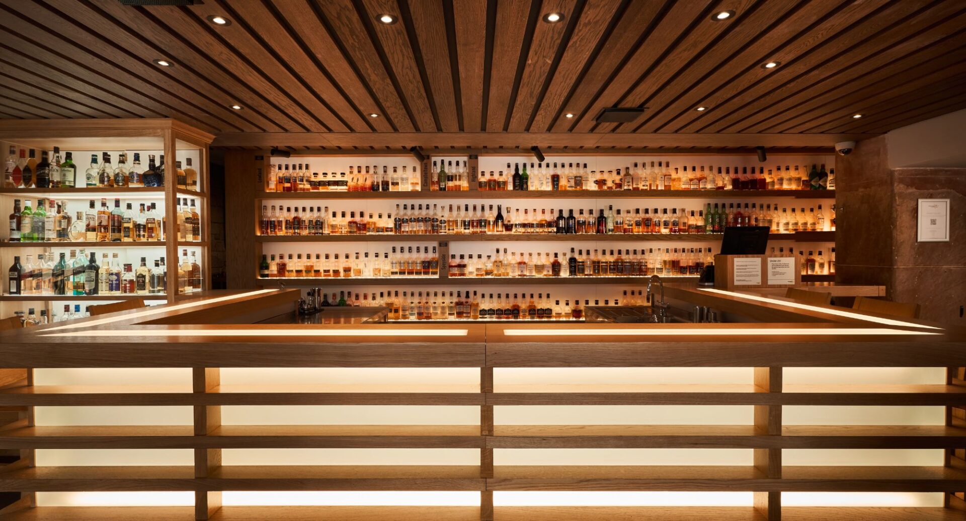 The Amber bar, showing rows of whisky bottles on wooden shelves