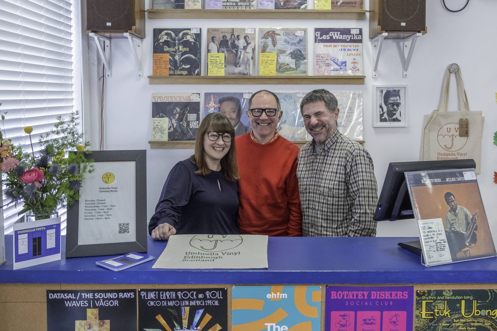 Umbrella Vinyl shop owners Laura, Josh & Nick standing behind the shop counter.
