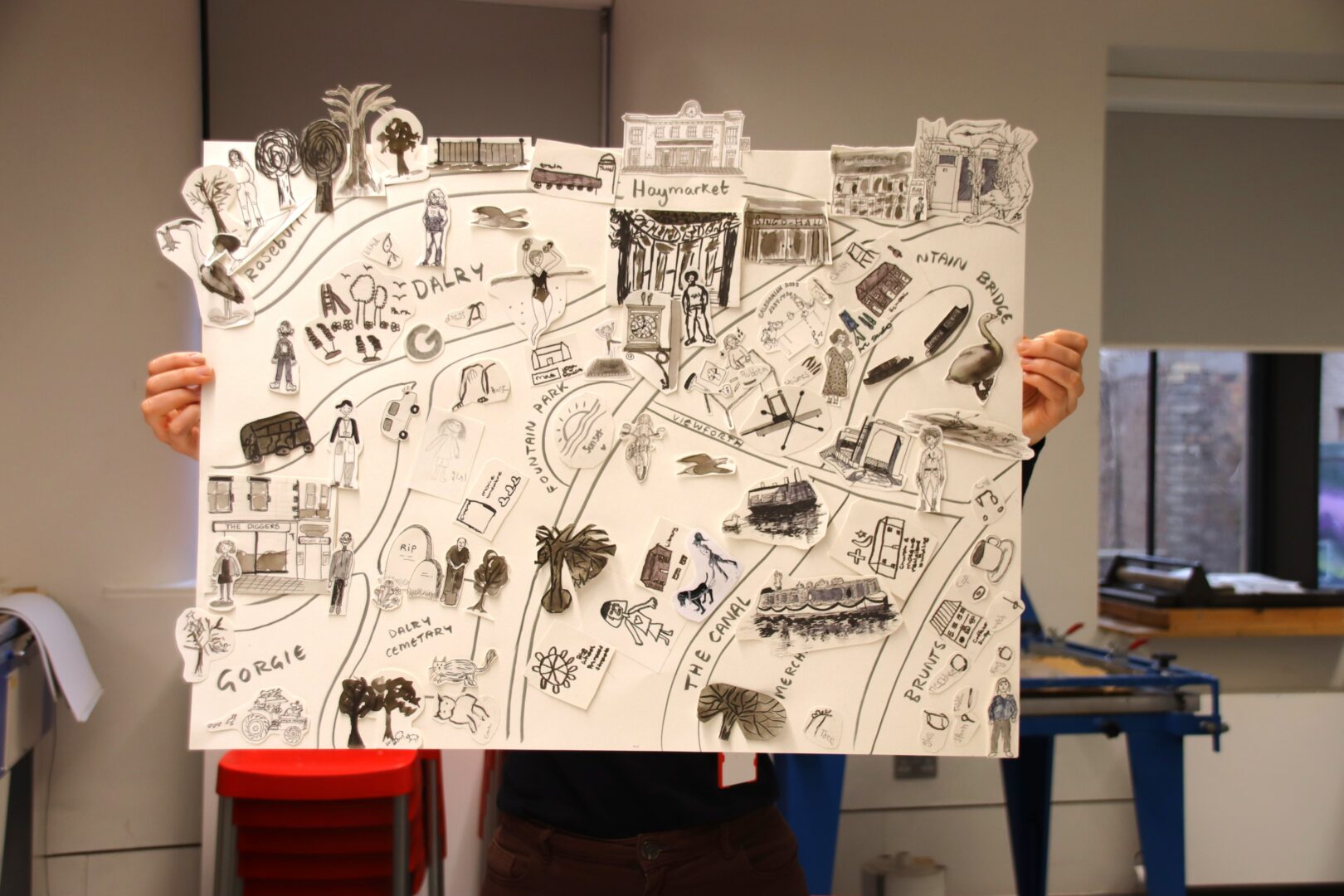 Two people holding up a large black and white applique-type map of Gorgie and Dalry