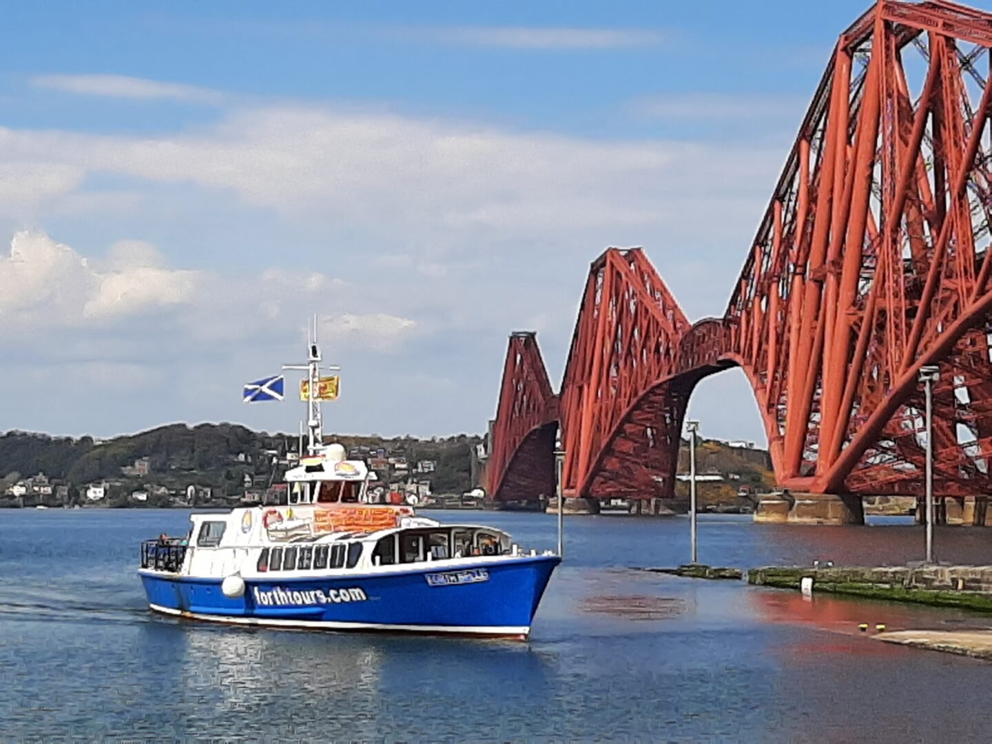 A boat sailing under the Forth Road Bridge