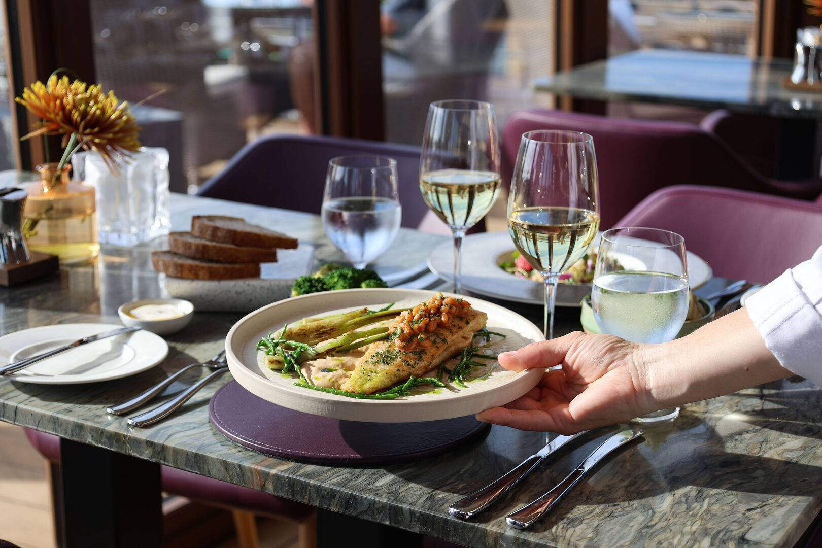 A Chef placing a fish dish onto the table in The Lighthouse Restaurant. ,© Latasha Millette