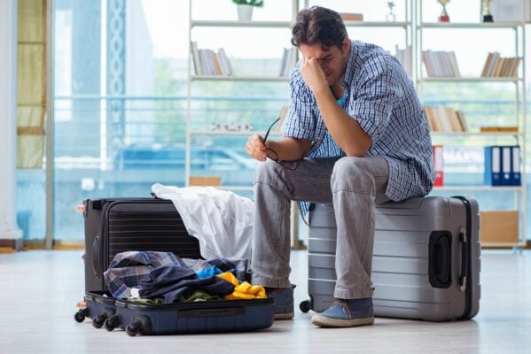 AiroLuggage man sitting on suitcase