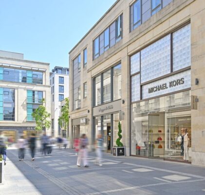 Multrees Walk walkway lined with brand store frontages including Michael Kors, Mappin & Webb and Max Mara,© Multrees Walk